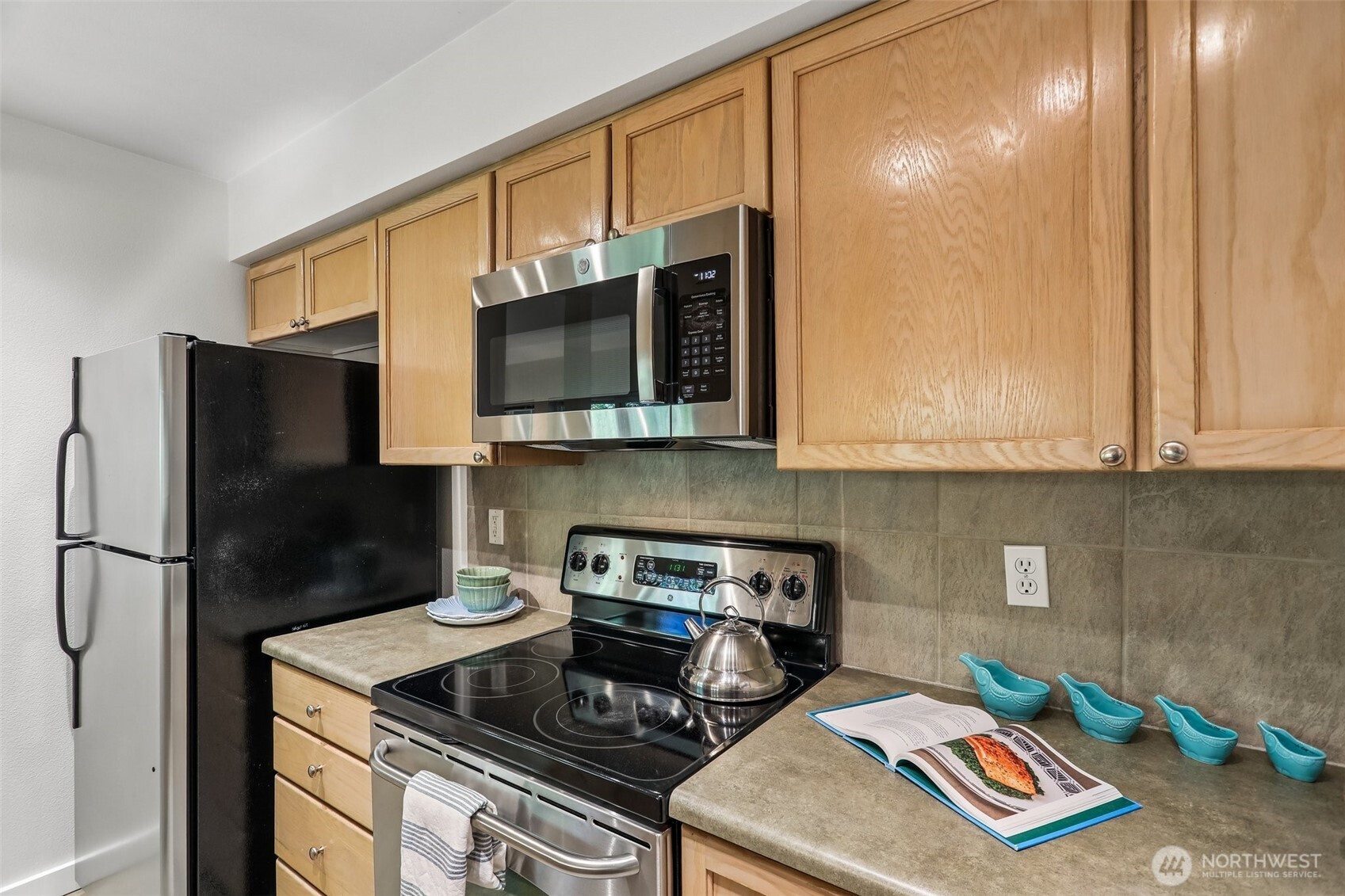 18930 Bothell Everett Highway, Unit E301 Bothell, WA 98012 - Photo 11 of 28 a kitchen with a stove a microwave and refrigerator