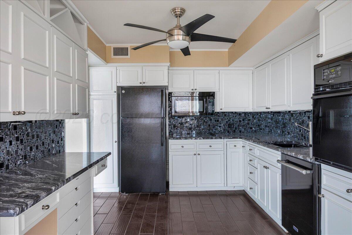 2028 South Austin Street, Unit 907 Amarillo, TX 79109 - Photo 11 of 39 a kitchen with stainless steel appliances granite countertop a refrigerator sink and white cabinets
