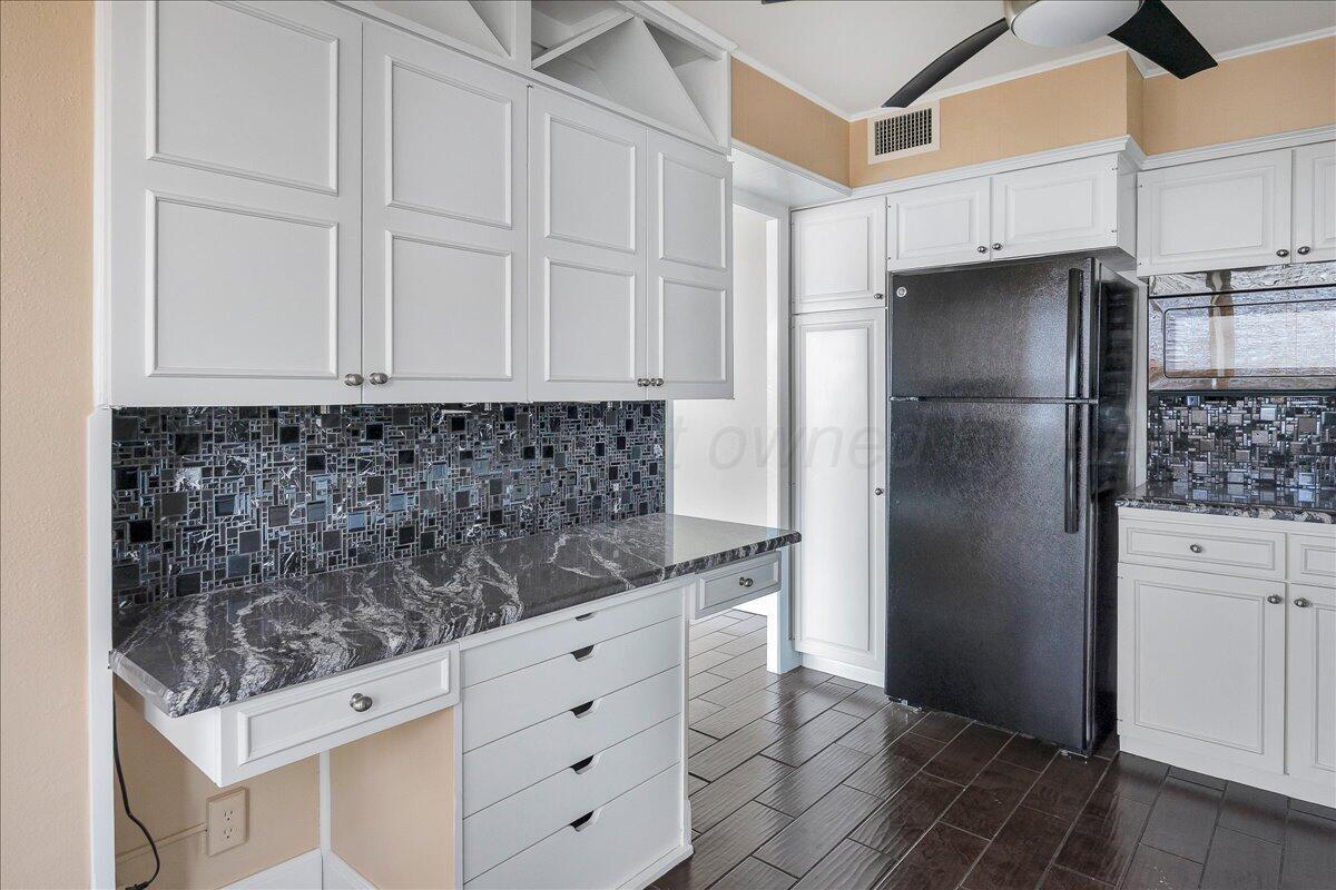 2028 South Austin Street, Unit 907 Amarillo, TX 79109 - Photo 12 of 39 a kitchen with white cabinets and refrigerator