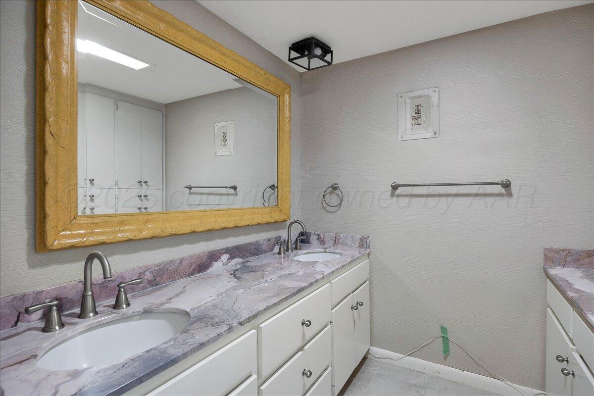 2028 South Austin Street, Unit 907 Amarillo, TX 79109 - Photo 18 of 39 a bathroom with a granite countertop sink a mirror and a toilet