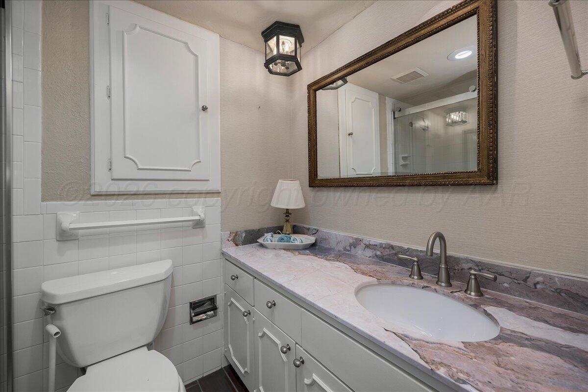2028 South Austin Street, Unit 907 Amarillo, TX 79109 - Photo 28 of 39 a bathroom with a granite countertop toilet sink and mirror