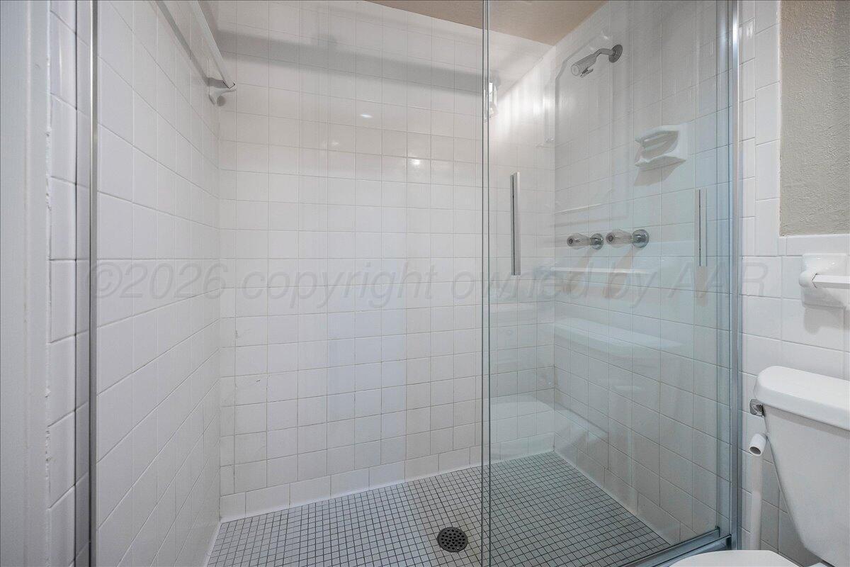 2028 South Austin Street, Unit 907 Amarillo, TX 79109 - Photo 29 of 39 a bathroom with a shower and a toilet