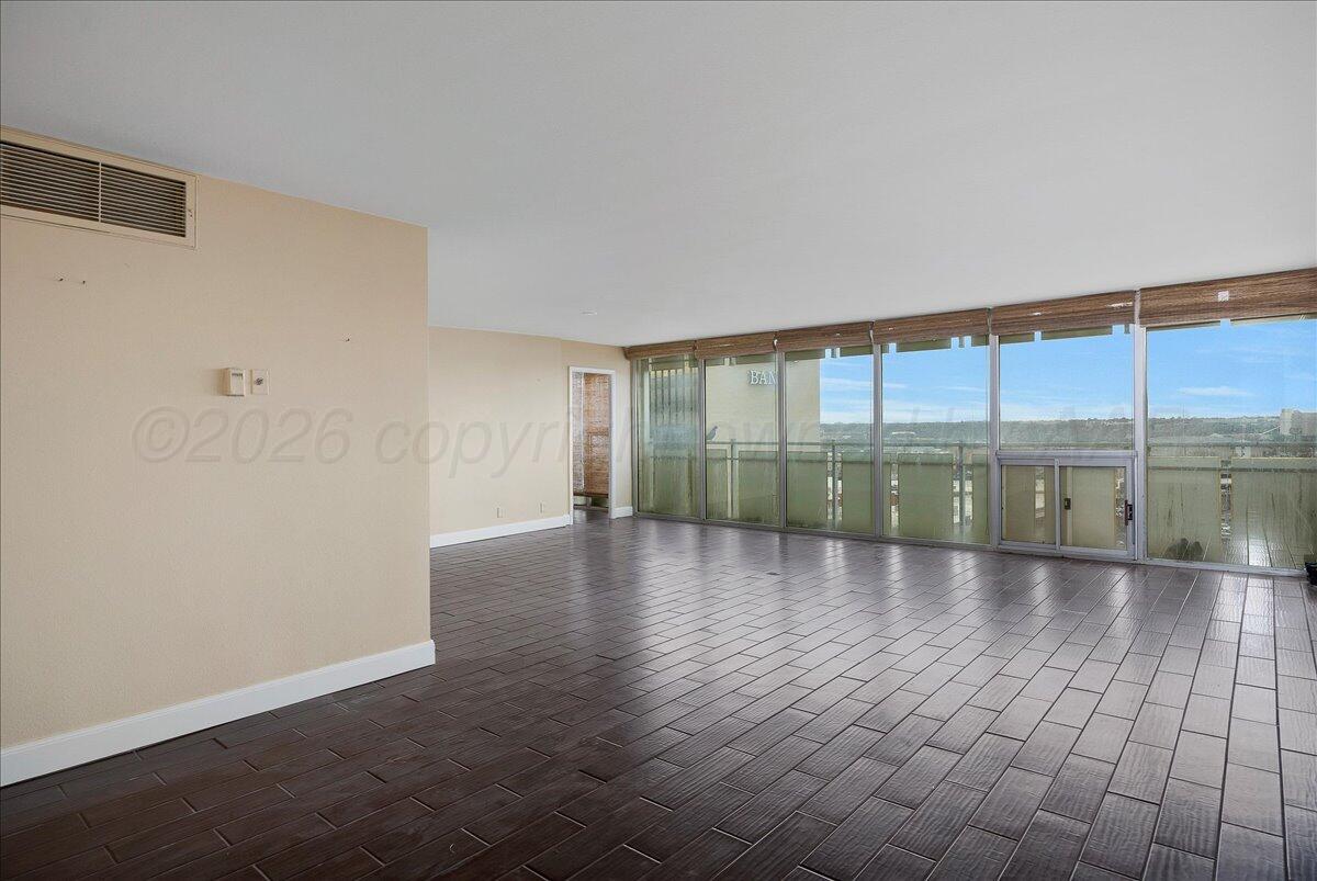 2028 South Austin Street, Unit 907 Amarillo, TX 79109 - Photo 3 of 39 wooden floor in an empty room with windows
