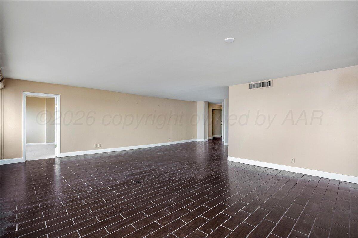 2028 South Austin Street, Unit 907 Amarillo, TX 79109 - Photo 7 of 39 a view of an empty room with wooden floor and a window