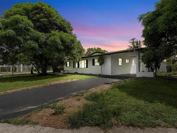a view of backyard of house with green space