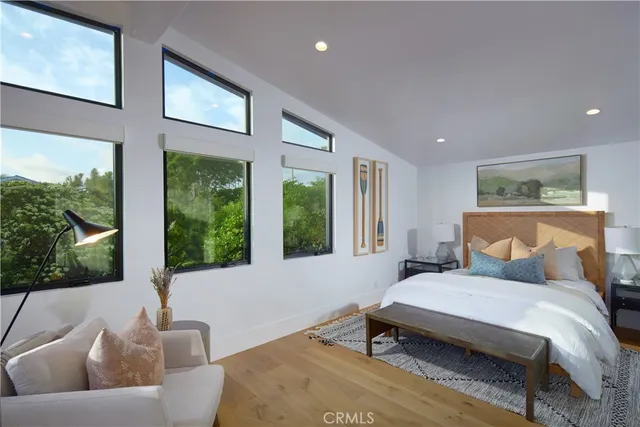 a bedroom with furniture and a large window