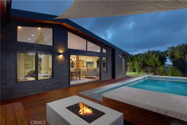 a view of a patio with couches table and chairs with wooden floor and fence