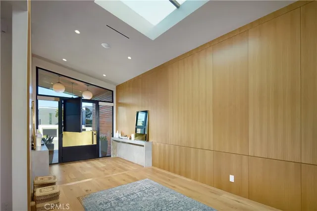 a view of a hallway with wooden floor and furniture