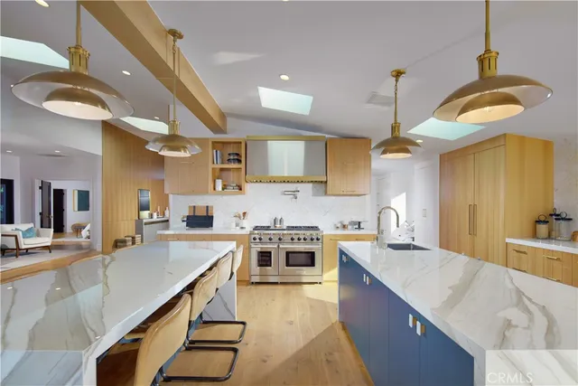 a kitchen with stainless steel appliances granite countertop a sink a stove and a wooden floors