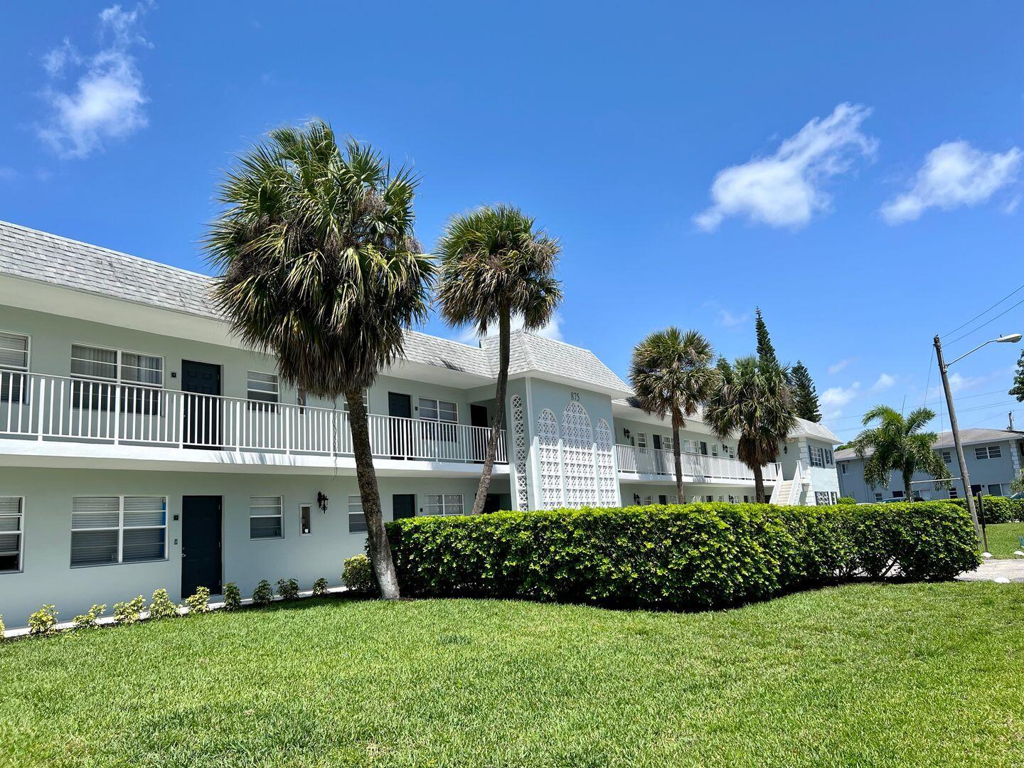 875 Southwest 4th Court, Unit 2 Boca Raton, FL 33432 - Photo 5 of 12 a view of a house with a yard and potted plants
