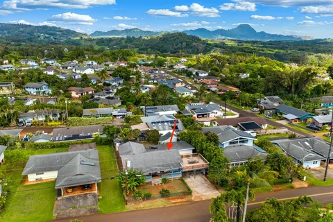 an aerial view of residential houses with outdoor space and ocean view