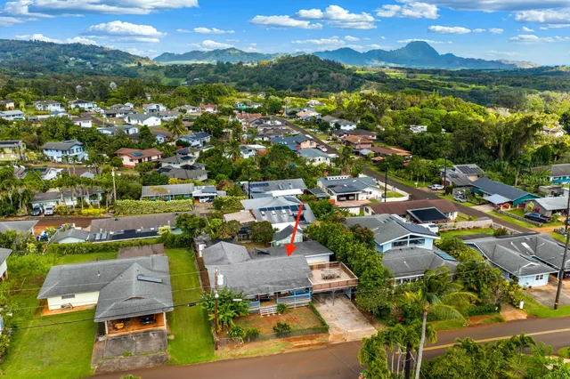 an aerial view of residential houses with outdoor space and ocean view