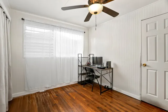 a view of a workspace with furniture and a window