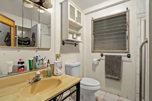 a bathroom with a sink a toilet and shower