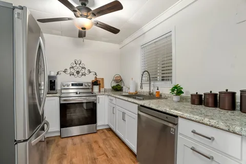 a kitchen with stainless steel appliances granite countertop a sink stove and refrigerator