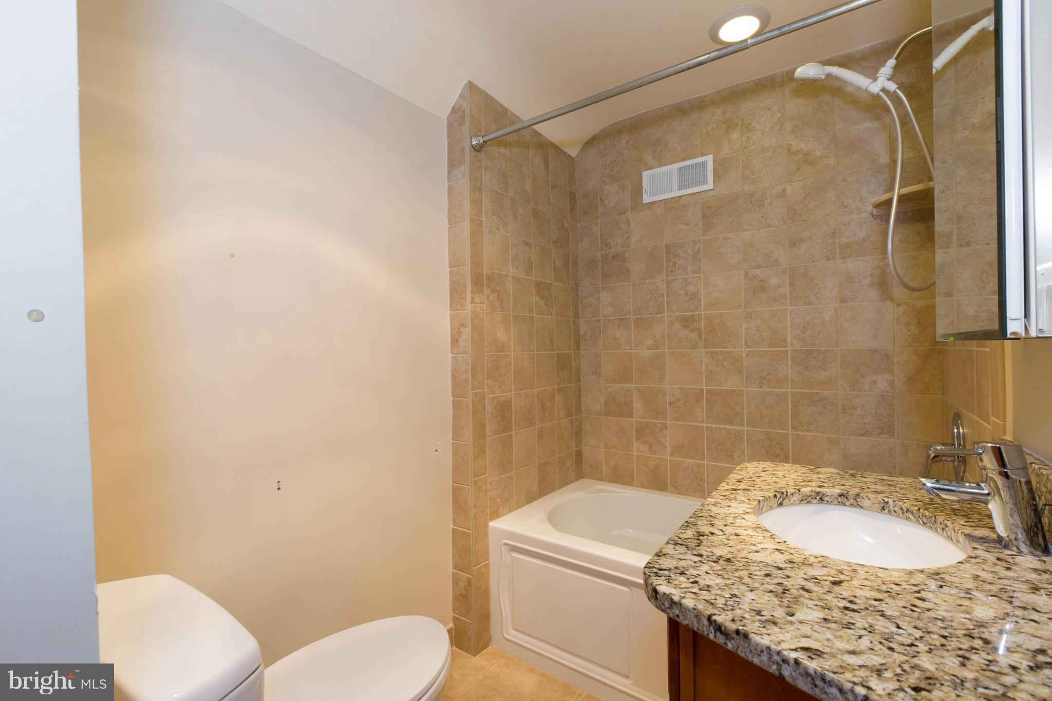 9600 Sutherland Road Silver Spring, MD 20901 - Photo 24 of 30 a bathroom with a granite countertop sink toilet and shower