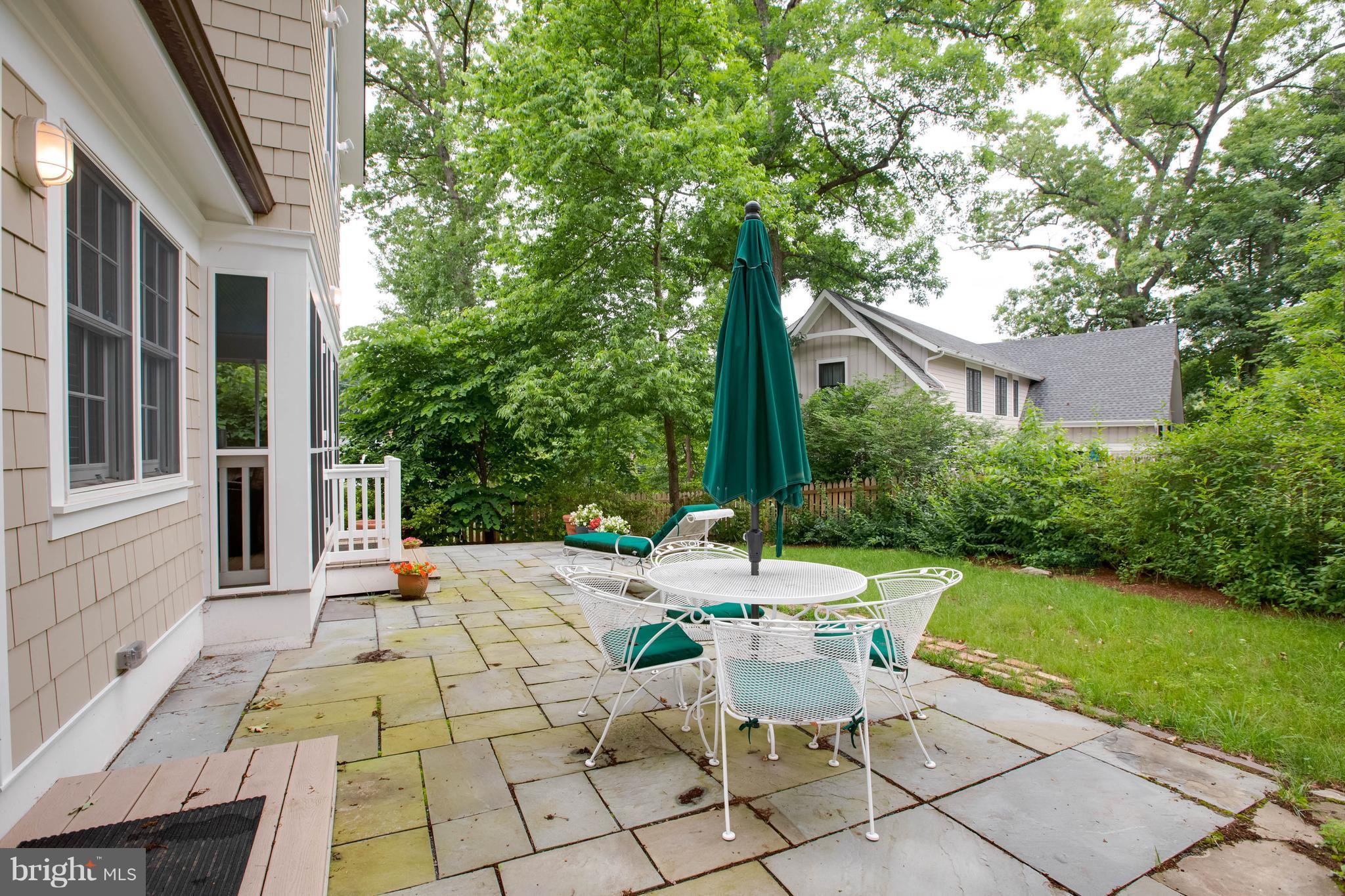 9600 Sutherland Road Silver Spring, MD 20901 - Photo 28 of 30 a view of a patio with a table and chairs under an umbrella with a big yard