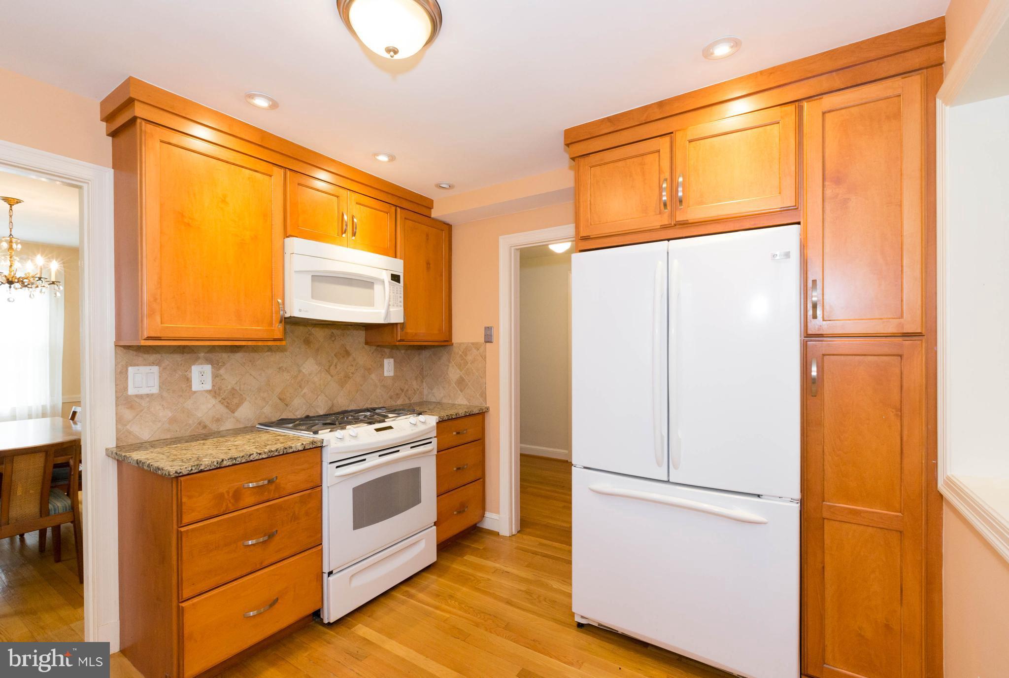 9600 Sutherland Road Silver Spring, MD 20901 - Photo 7 of 30 a kitchen with stainless steel appliances a refrigerator sink and cabinets