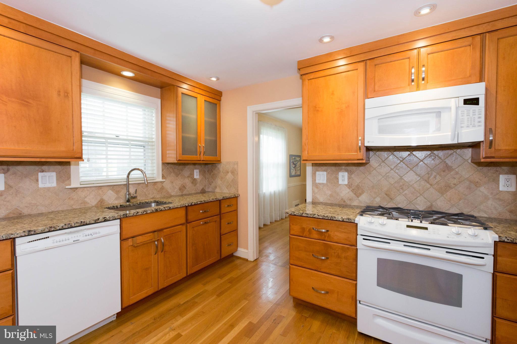 9600 Sutherland Road Silver Spring, MD 20901 - Photo 8 of 30 a kitchen with a stove a sink and a microwave