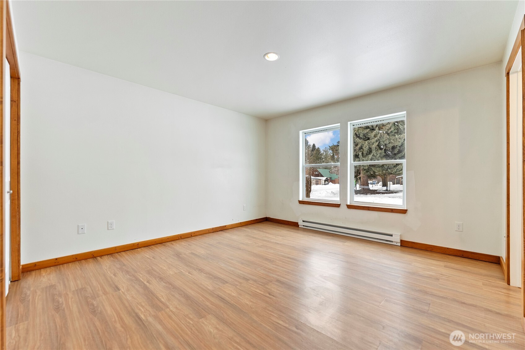 203 Washington Street Winthrop, WA 98862 - Photo 18 of 39 an empty room with wooden floor and windows