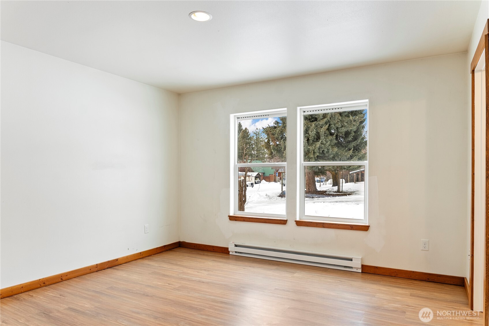 203 Washington Street Winthrop, WA 98862 - Photo 19 of 39 an empty room with wooden floor and windows