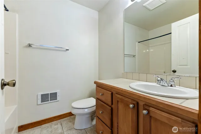 a bathroom with a granite countertop sink a toilet and a mirror