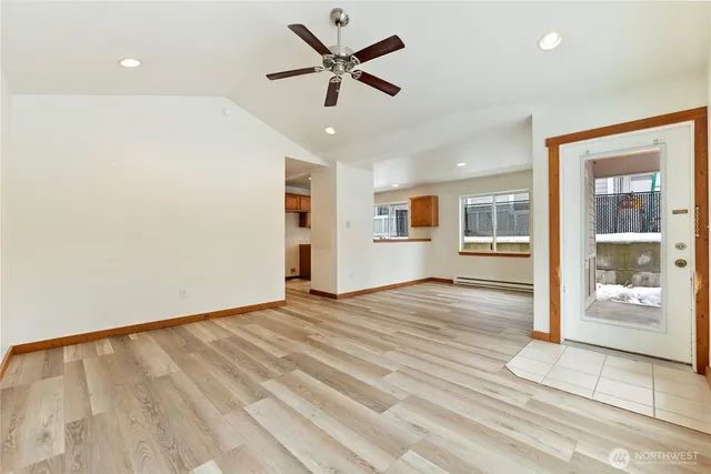 a view of an empty room with window and wooden floor