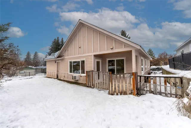 a view of a house with a yard covered in snow