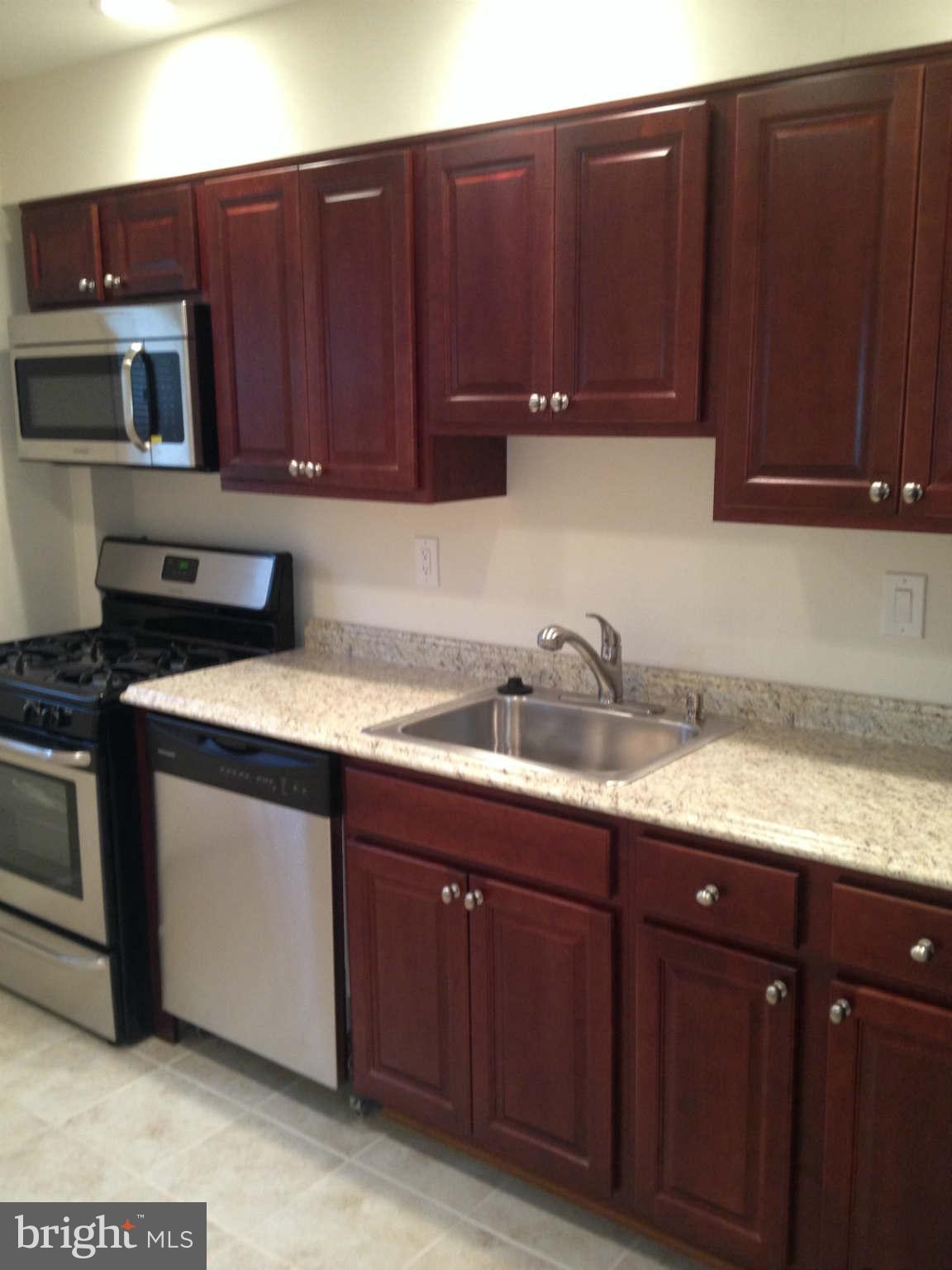 907 Masefield Road Baltimore, MD 21207 - Photo 2 of 23 a kitchen with sink cabinets and stainless steel appliances
