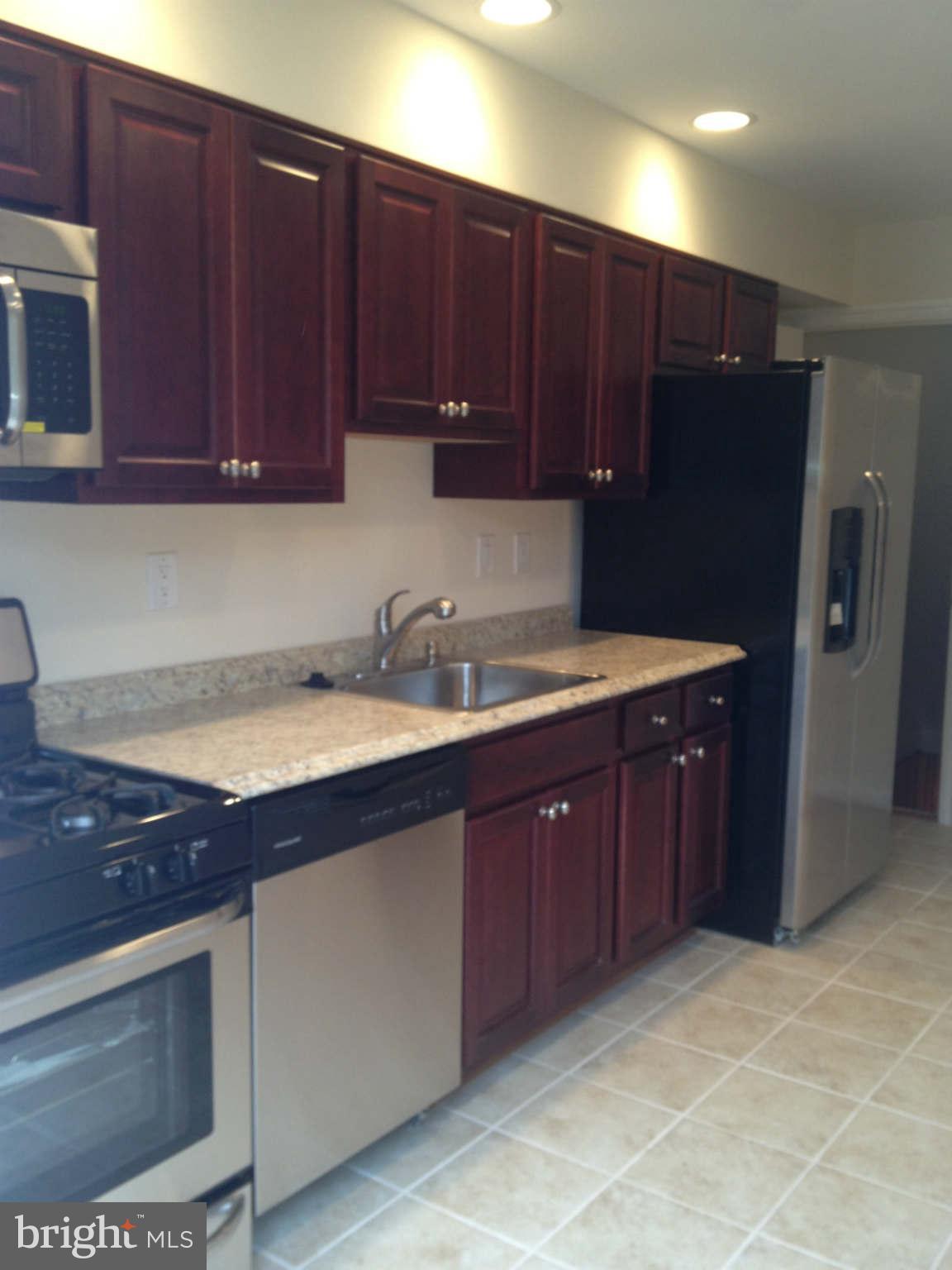 907 Masefield Road Baltimore, MD 21207 - Photo 11 of 23 a kitchen with wooden cabinets