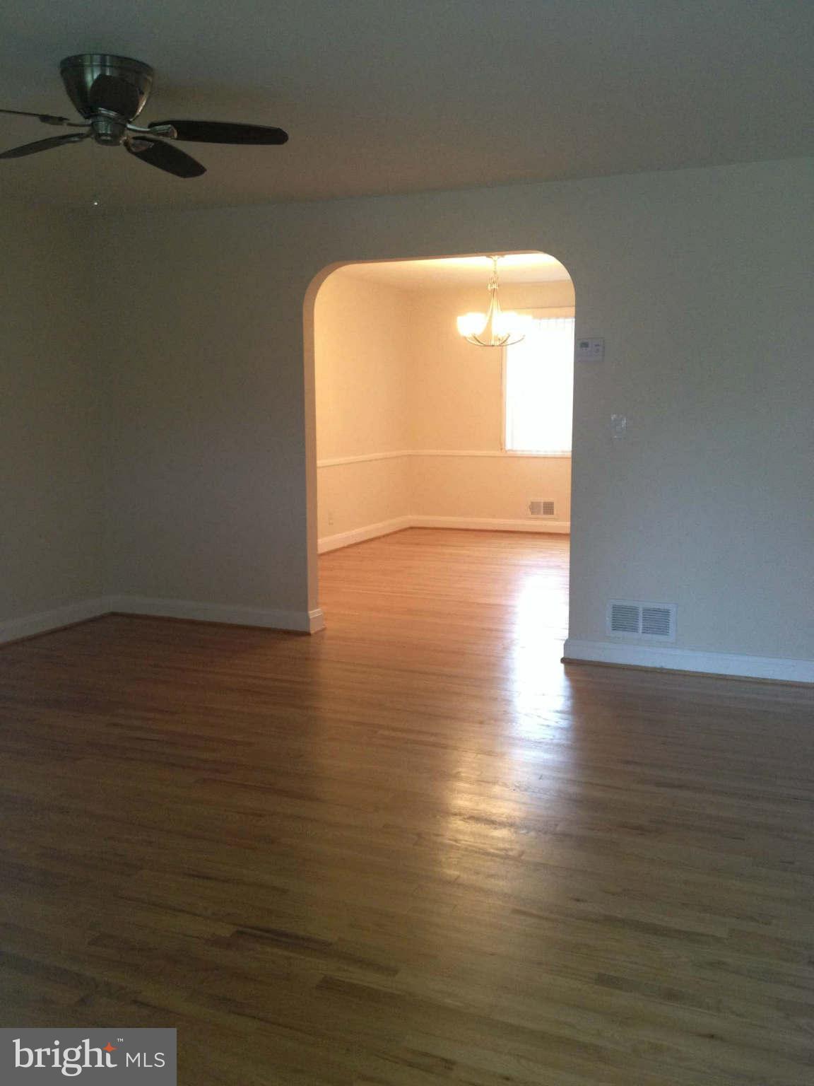 907 Masefield Road Baltimore, MD 21207 - Photo 3 of 23 a view of empty room with wooden floor and windows
