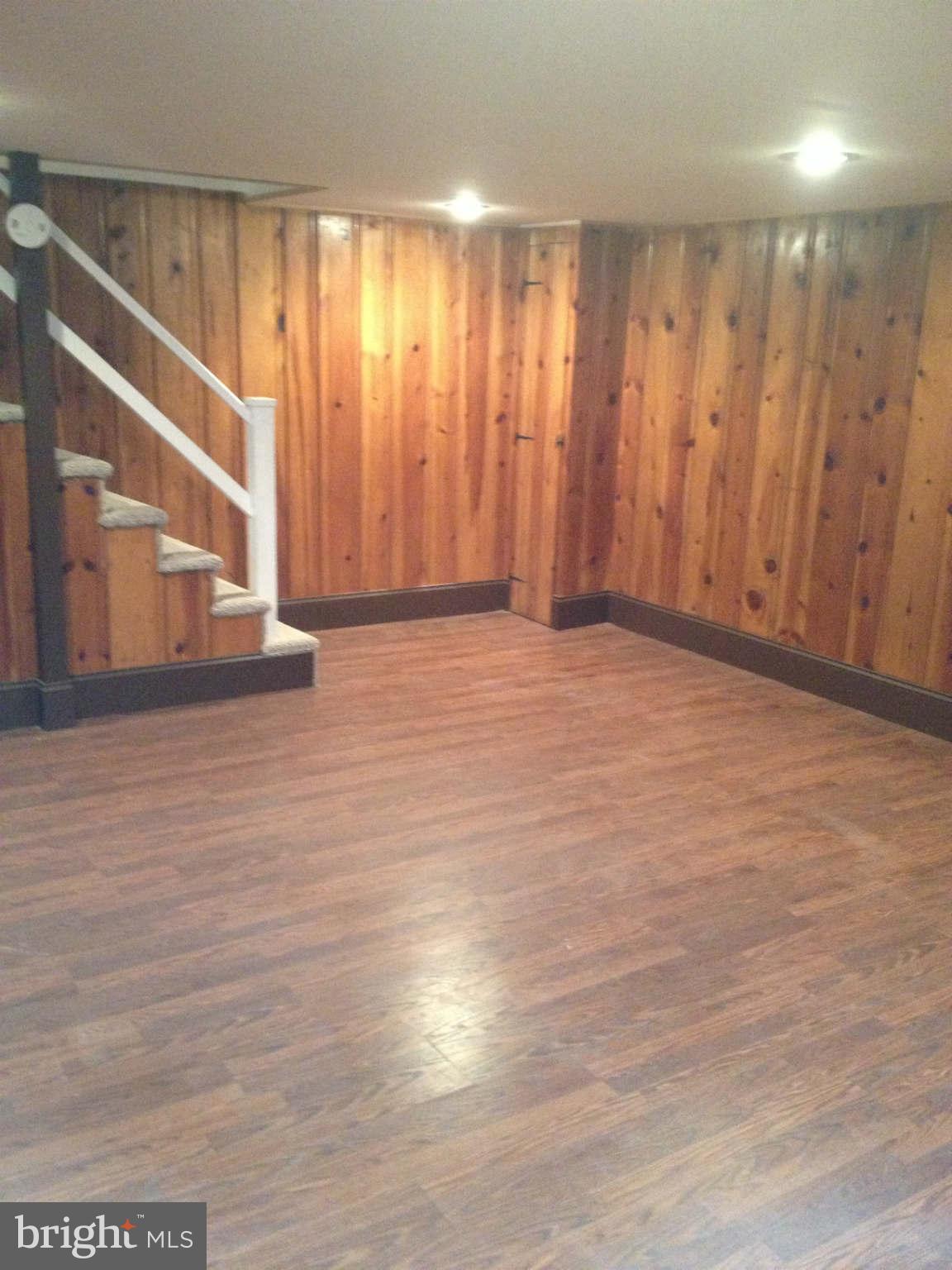 907 Masefield Road Baltimore, MD 21207 - Photo 5 of 23 a view of an empty room with wooden floor and a window