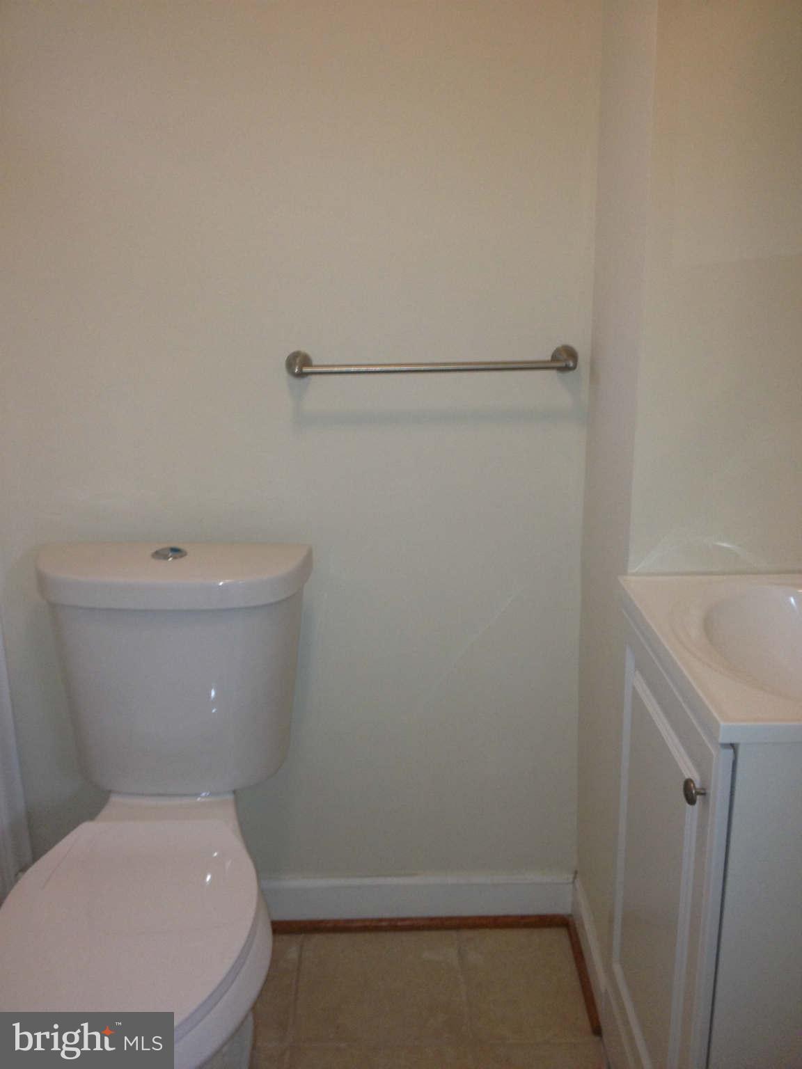 907 Masefield Road Baltimore, MD 21207 - Photo 9 of 23 a white toilet sitting next to a sink