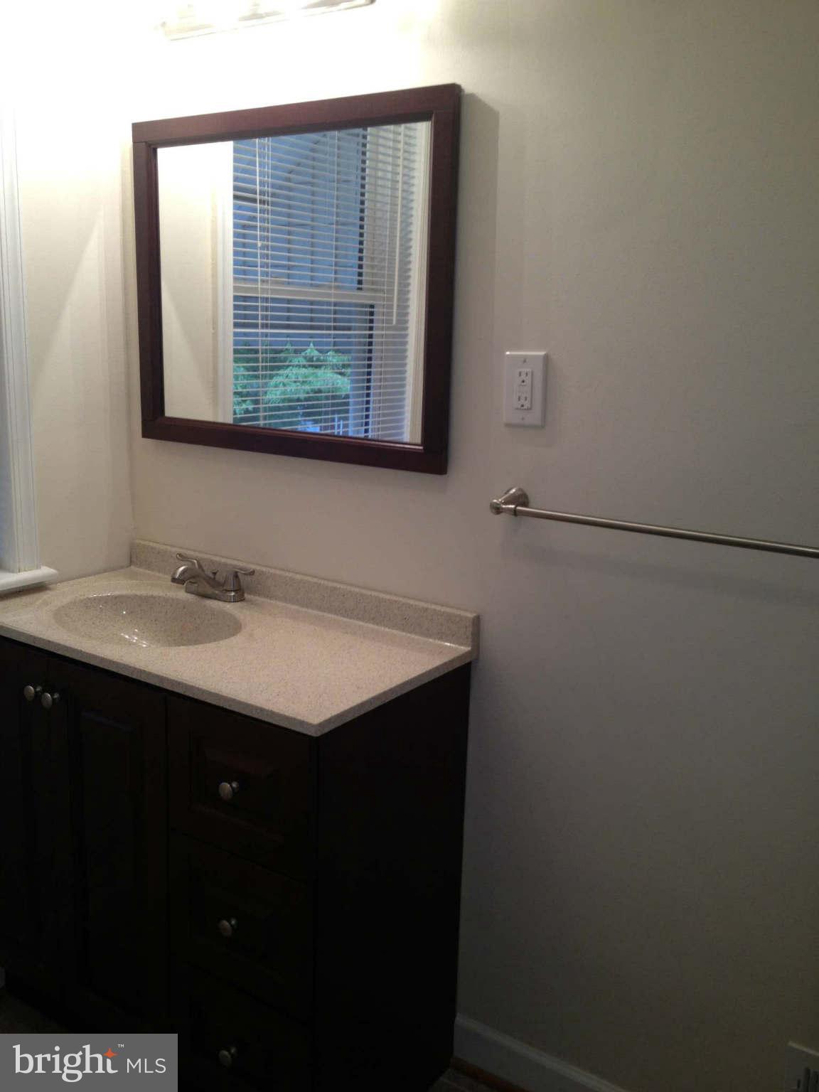 907 Masefield Road Baltimore, MD 21207 - Photo 10 of 23 a bathroom with a sink vanity and a mirror