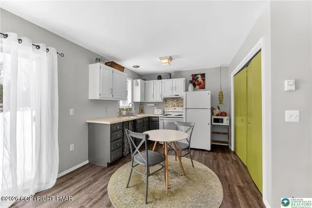 a kitchen with stainless steel appliances a dining table chairs and a refrigerator