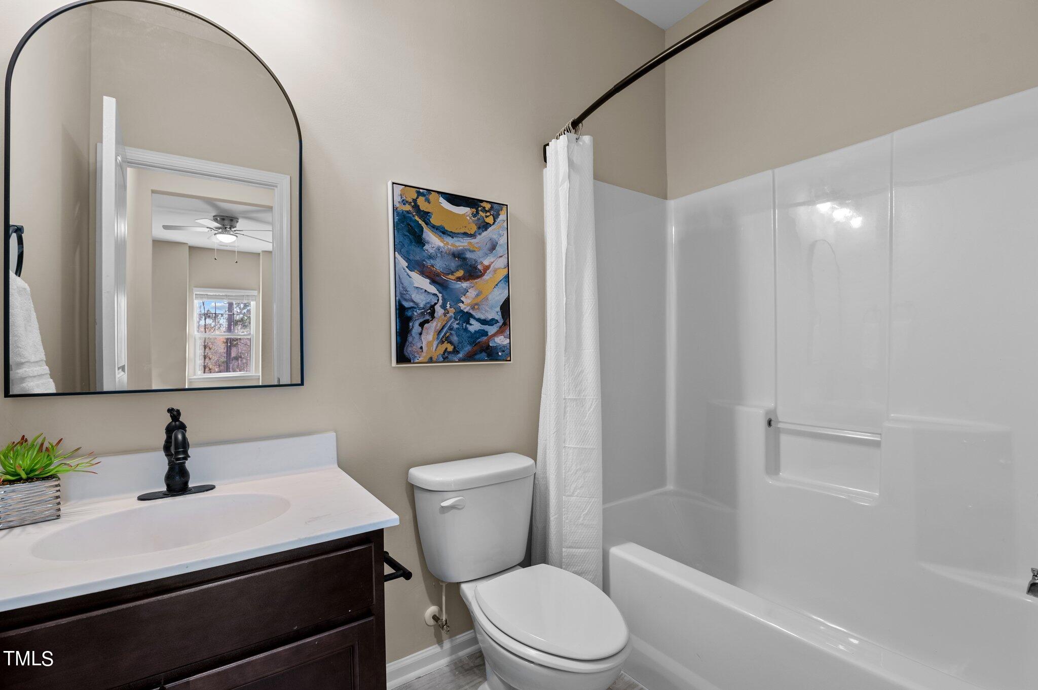 2009 Delphi Way Wake Forest, NC 27587 - Photo 33 of 40 a bathroom with a sink a toilet a mirror a vanity and shower