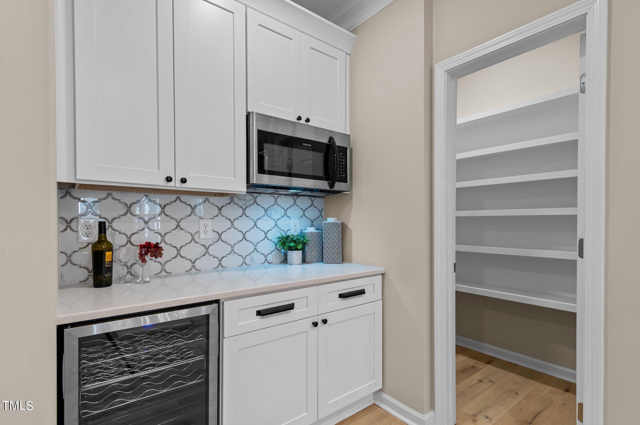 2009 Delphi Way Wake Forest, NC 27587 - Photo 9 of 40 a kitchen with white cabinets and black appliances