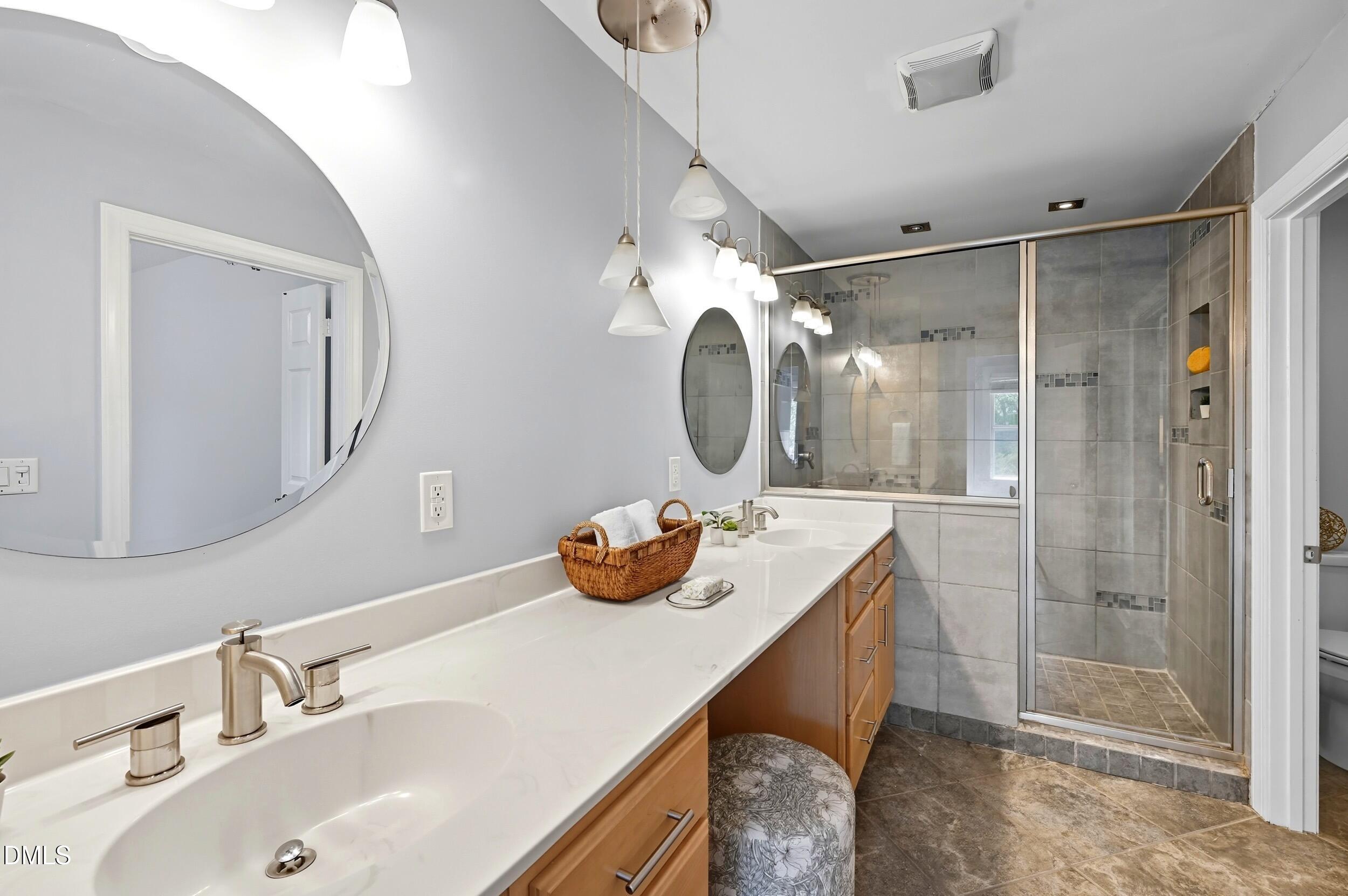 4111 Settlement Drive Durham, NC 27713 - Photo 16 of 25 a bathroom with a sink mirror and shower