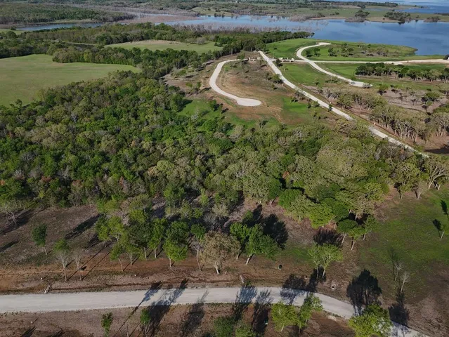an aerial view of a house with a yard and lake