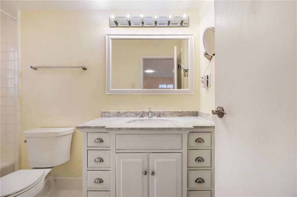 4300 Roswell Road Northeast, Unit 4303 Atlanta, GA 30342 - Photo 23 of 39 a bathroom with a sink a toilet and a mirror