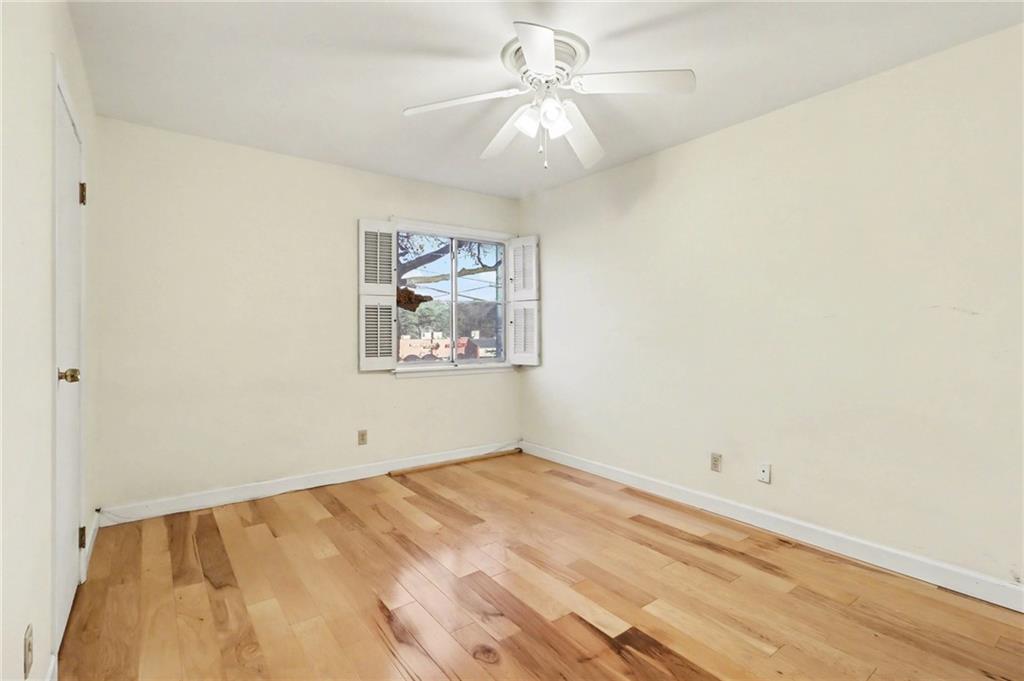 4300 Roswell Road Northeast, Unit 4303 Atlanta, GA 30342 - Photo 28 of 39 an empty room with a ceiling fan and wooden floor