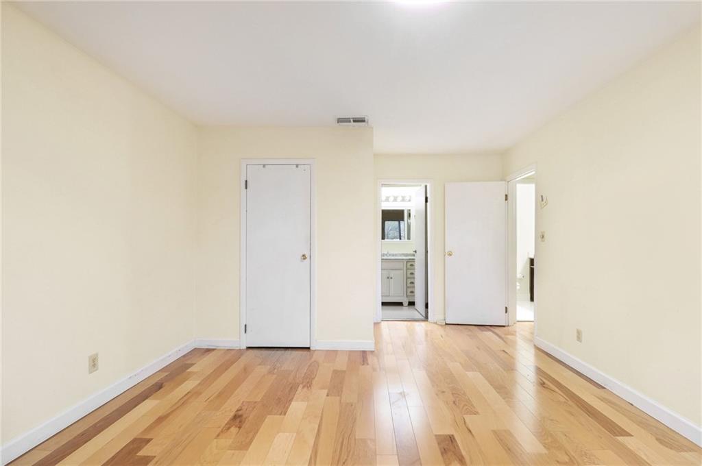 4300 Roswell Road Northeast, Unit 4303 Atlanta, GA 30342 - Photo 33 of 39 an empty room with wooden floor and windows