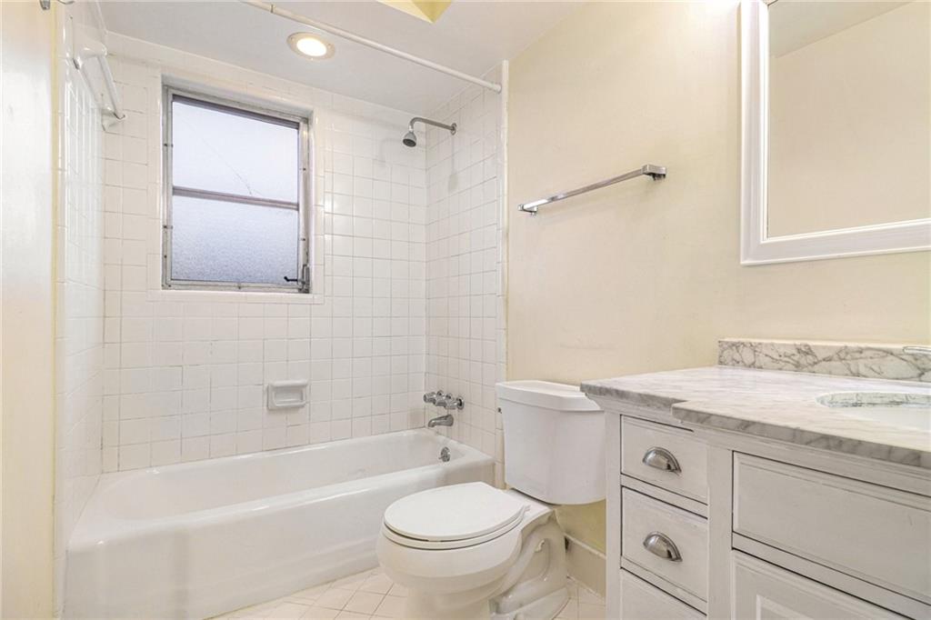 4300 Roswell Road Northeast, Unit 4303 Atlanta, GA 30342 - Photo 36 of 39 a bathroom with a granite countertop toilet a sink and a bathtub