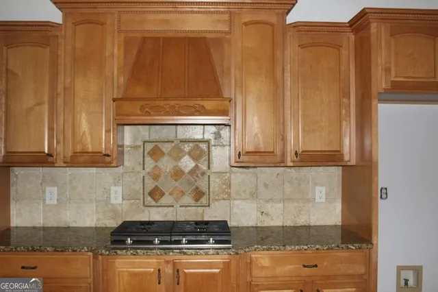 a kitchen with granite countertop white cabinets and stainless steel appliances