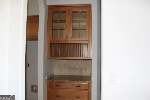 a kitchen with granite countertop white cabinets and stainless steel appliances