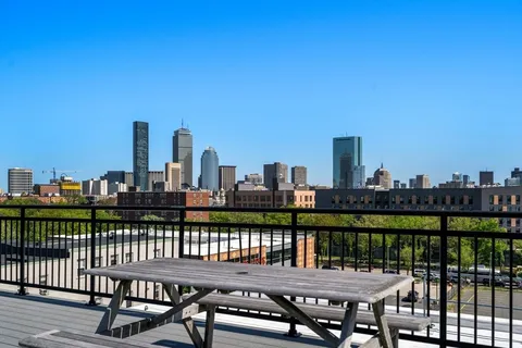 a view of a roof deck with two chairs and a table