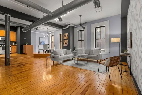 a living room with furniture and a wooden floor