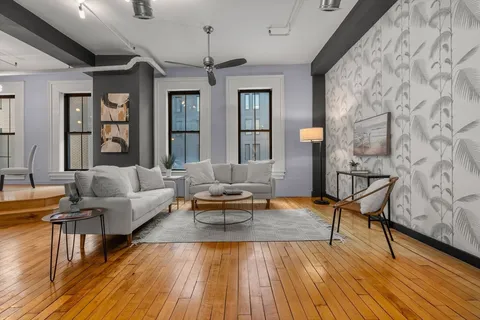 a living room with patio furniture and wooden floor