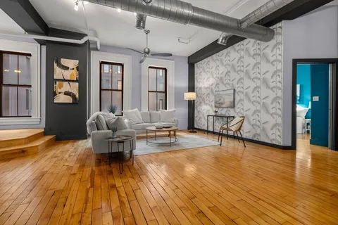 a living room with furniture and a wooden floor