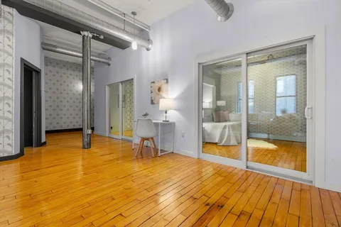 a view of a room with wooden floor and furniture